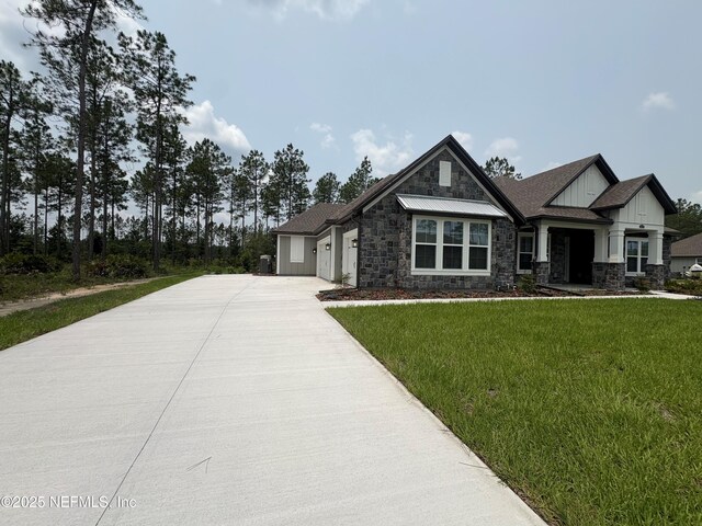 36215 Pitch Ln, Hilliard, FL 32046 - view of front of property with stone siding, driveway, a garage, and a front yard