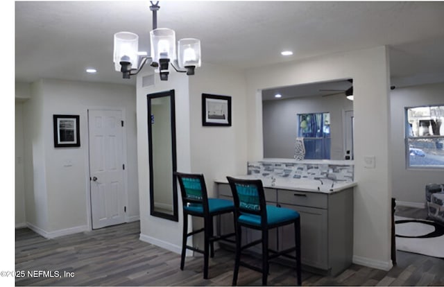 bar with baseboards, pendant lighting, wood finished floors, and recessed lighting