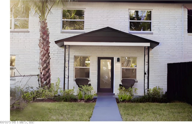 view of exterior entry featuring brick siding