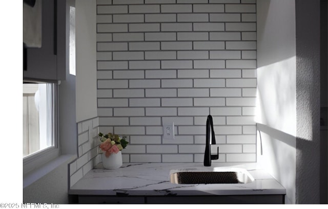 interior details featuring a sink and decorative backsplash