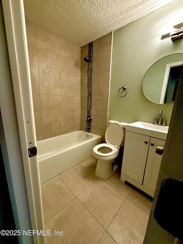 bathroom with a textured ceiling, vanity, toilet, and tile patterned floors