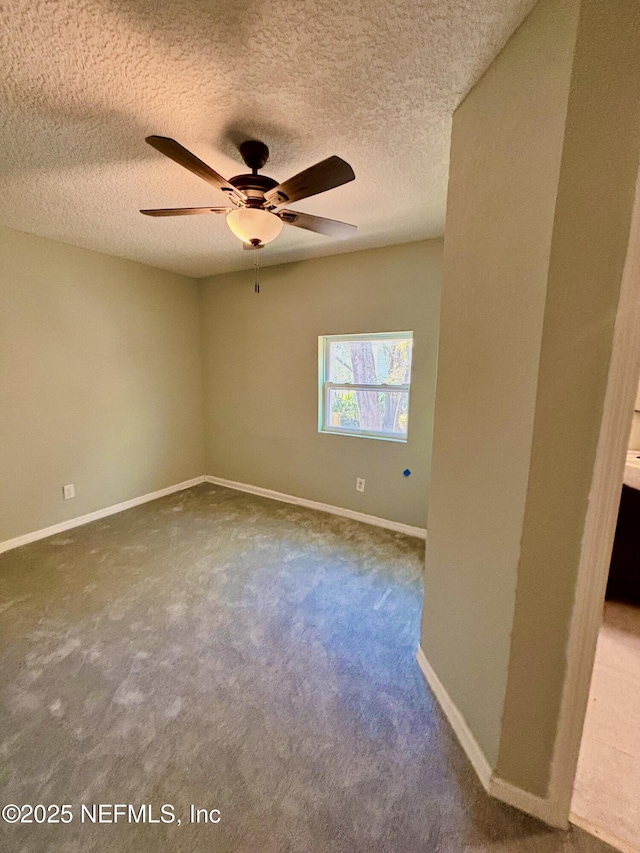 empty room with carpet floors, ceiling fan, baseboards, and a textured ceiling