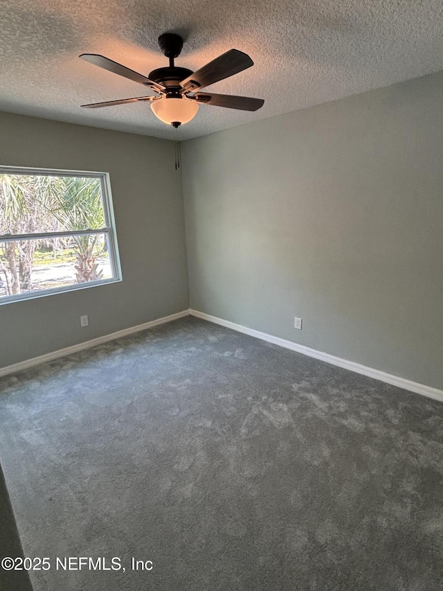 unfurnished room featuring dark carpet, a textured ceiling, baseboards, and ceiling fan