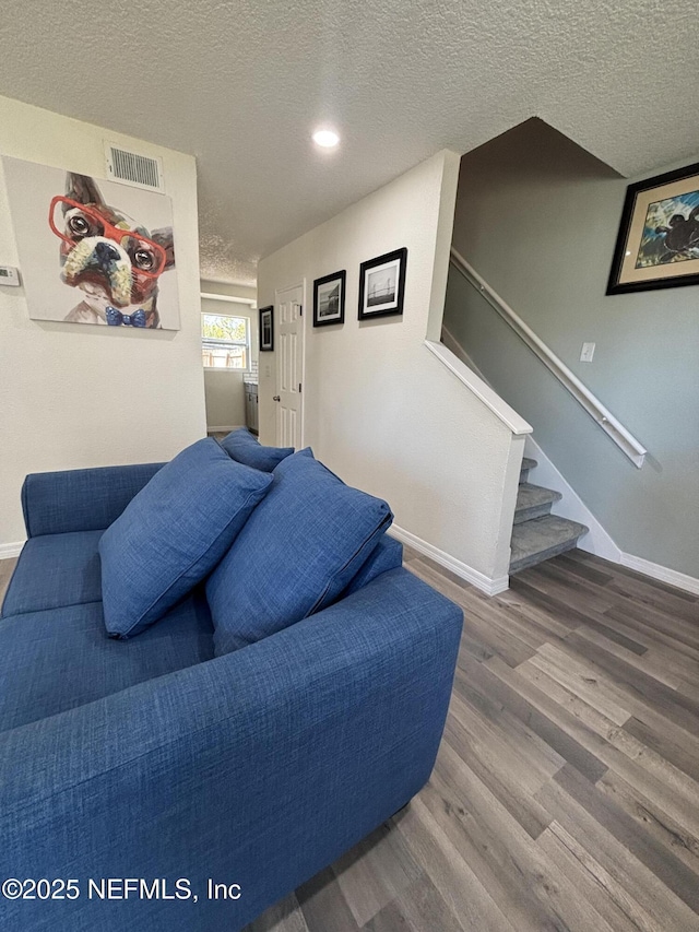 bedroom with a textured ceiling, recessed lighting, wood finished floors, visible vents, and baseboards