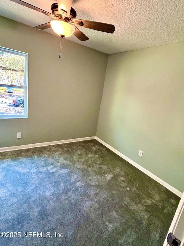 unfurnished room featuring dark colored carpet, ceiling fan, a textured ceiling, and baseboards