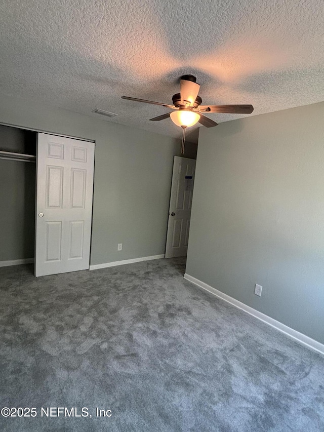 unfurnished bedroom with baseboards, ceiling fan, a textured ceiling, carpet flooring, and a closet