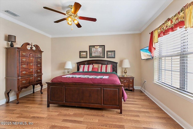 bedroom featuring ornamental molding, light wood-type flooring, visible vents, and baseboards