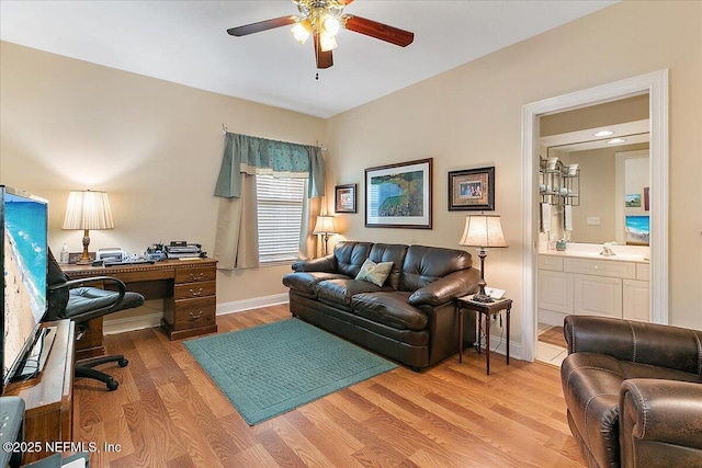 home office featuring light wood-type flooring, a ceiling fan, and baseboards