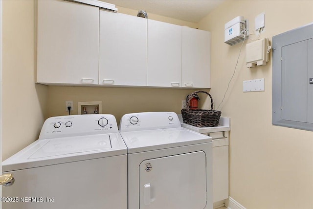 laundry area featuring cabinet space, electric panel, baseboards, and washer and clothes dryer