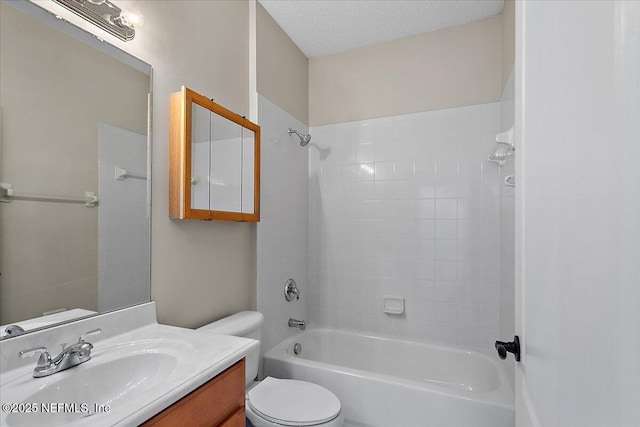 full bath featuring shower / bath combination, a textured ceiling, toilet, and vanity