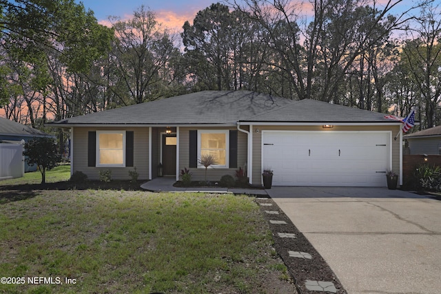 ranch-style house featuring driveway, a front yard, and an attached garage