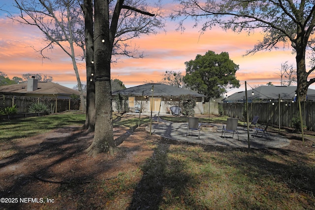 rear view of house featuring a patio area, a yard, an outdoor fire pit, and a fenced backyard