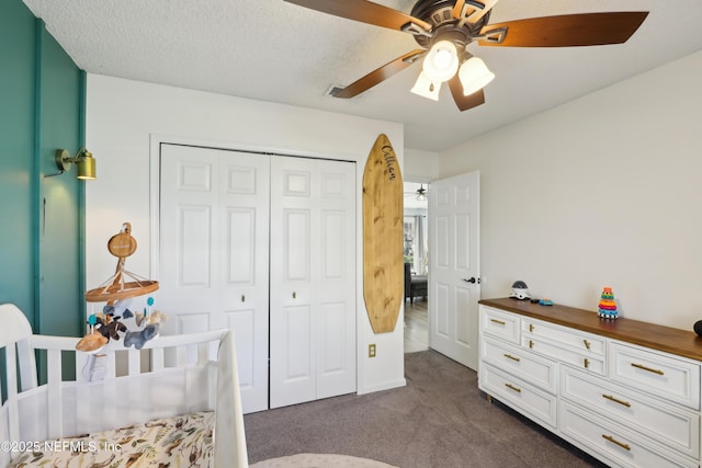 bedroom featuring a ceiling fan, visible vents, a closet, a textured ceiling, and dark colored carpet