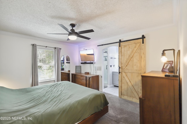 bedroom with light colored carpet, crown molding, and a barn door