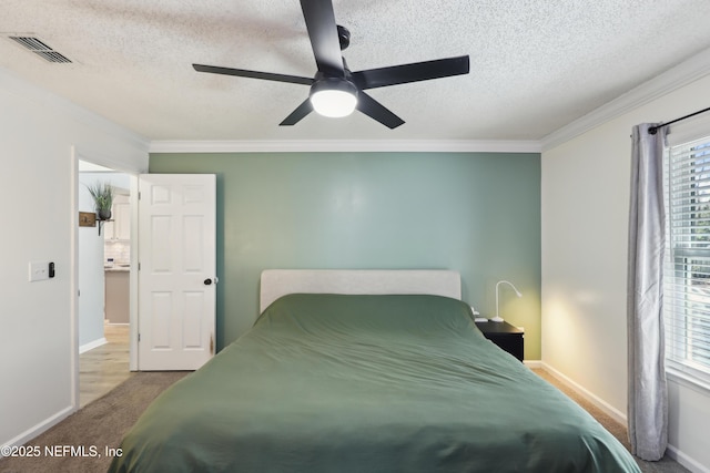 carpeted bedroom featuring a ceiling fan, baseboards, visible vents, ornamental molding, and a textured ceiling