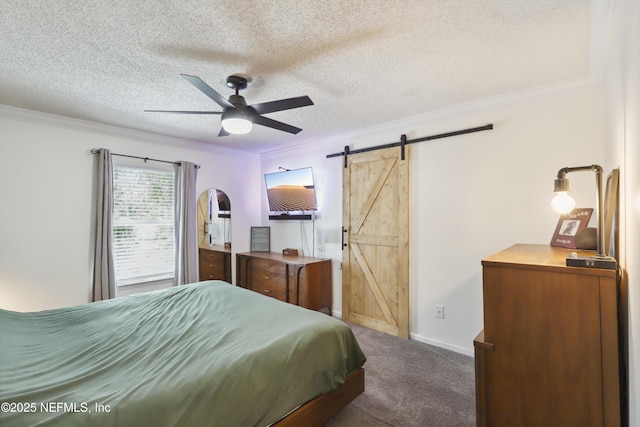 bedroom featuring ceiling fan, dark carpet, a barn door, ornamental molding, and a textured ceiling