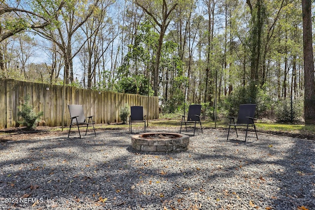 view of yard with fence and a fire pit