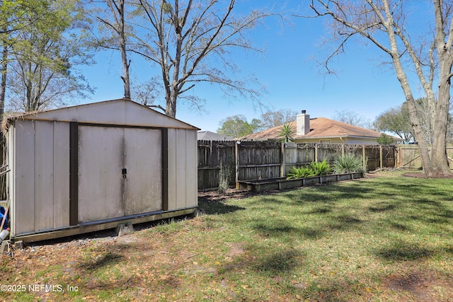 view of yard with an outbuilding, a storage unit, and a fenced backyard