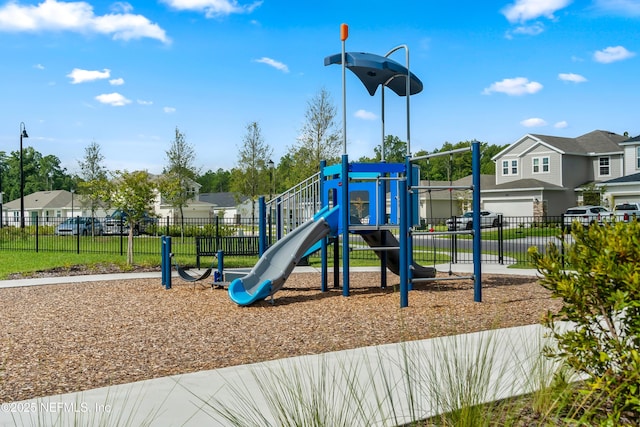 community jungle gym with fence and a residential view