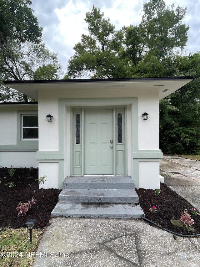 property entrance featuring stucco siding