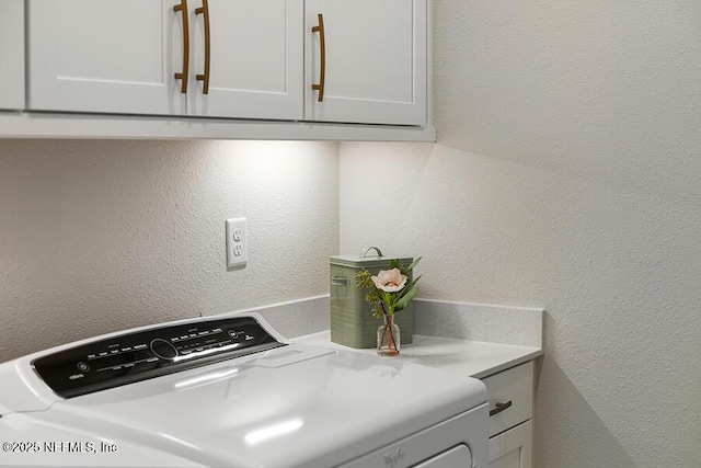 kitchen with a textured wall, washing machine and dryer, and light countertops