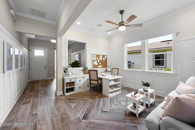 office featuring visible vents, crown molding, ceiling fan, a decorative wall, and parquet floors