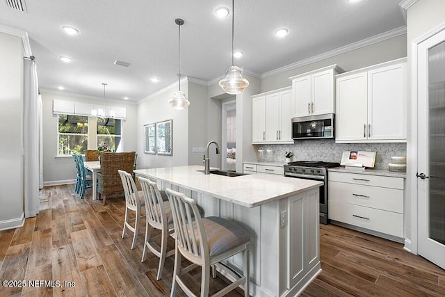 kitchen with a sink, crown molding, backsplash, and stainless steel appliances