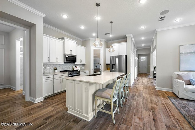 kitchen with visible vents, dark wood finished floors, a sink, stainless steel appliances, and white cabinets