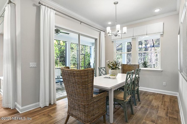 dining room with a chandelier, baseboards, wood finished floors, and crown molding