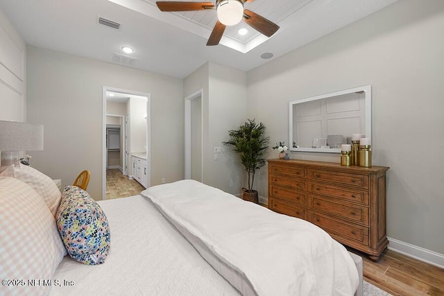 bedroom featuring visible vents, ensuite bath, light wood-type flooring, and baseboards