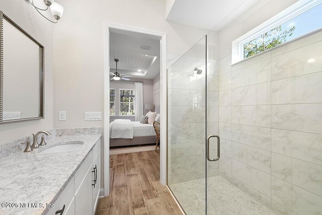 ensuite bathroom with ensuite bath, a healthy amount of sunlight, wood finished floors, and a shower stall