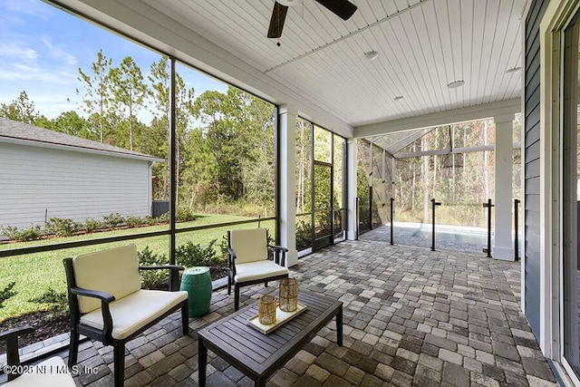 unfurnished sunroom featuring wooden ceiling and a ceiling fan