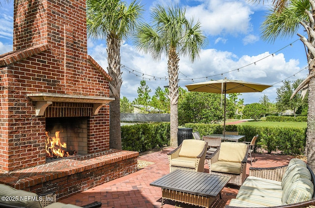 view of patio / terrace featuring fence and an outdoor brick fireplace