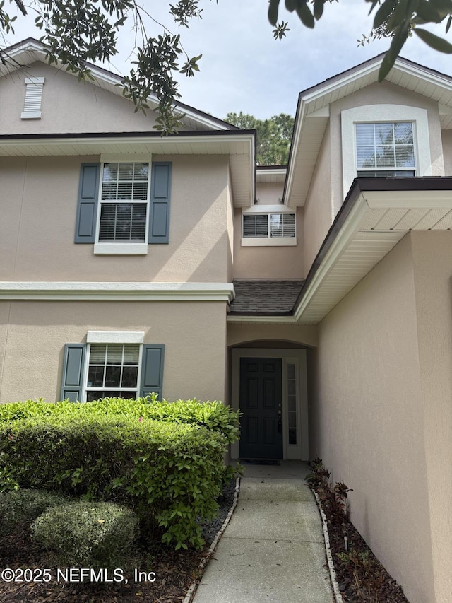 entrance to property featuring stucco siding