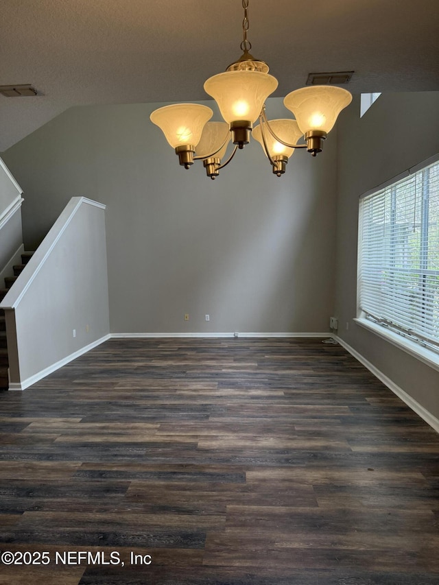 unfurnished dining area with dark wood-style flooring, baseboards, an inviting chandelier, and stairs