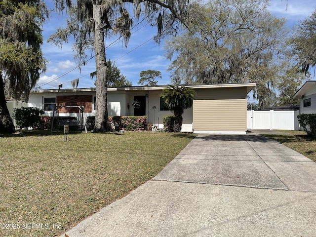 single story home with driveway, a front yard, and fence