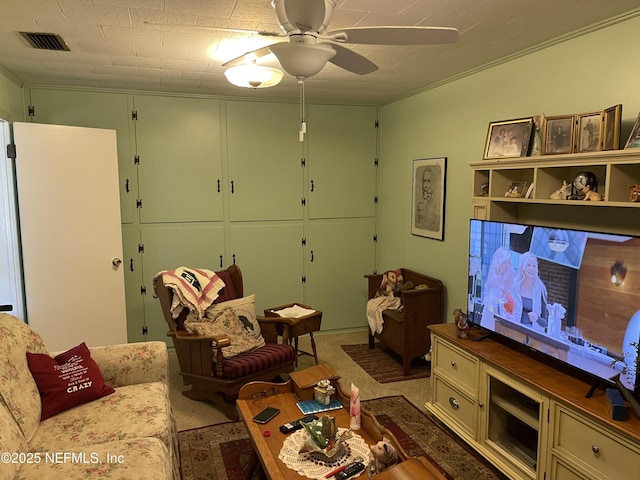 living area with visible vents, carpet, and a ceiling fan