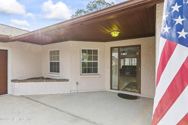 doorway to property featuring a patio area and stucco siding