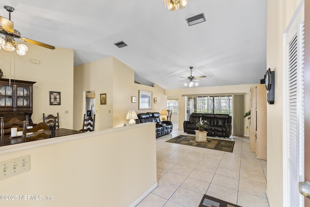 entryway featuring light tile patterned floors, ceiling fan, visible vents, and vaulted ceiling