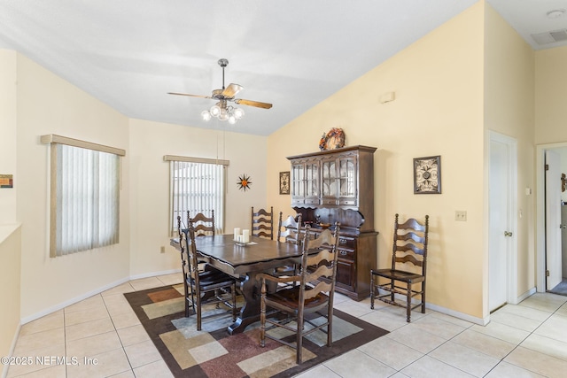 dining space with light tile patterned flooring, visible vents, baseboards, vaulted ceiling, and a ceiling fan