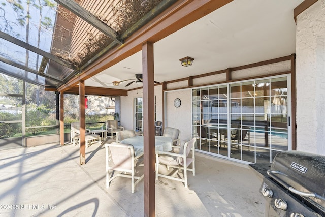 view of patio / terrace with outdoor dining area, glass enclosure, ceiling fan, and grilling area