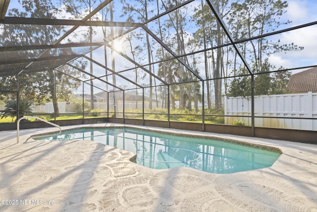 outdoor pool with glass enclosure, a patio, and fence