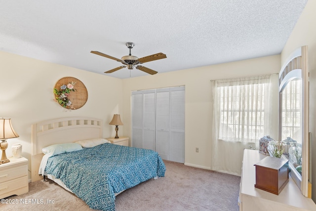 bedroom with a closet, a ceiling fan, carpet flooring, a textured ceiling, and baseboards