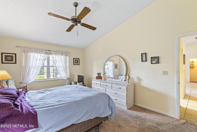 carpeted bedroom featuring vaulted ceiling, ceiling fan, a textured ceiling, and baseboards