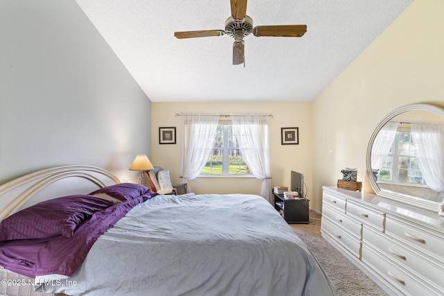 bedroom featuring a textured ceiling, carpet flooring, a ceiling fan, and lofted ceiling