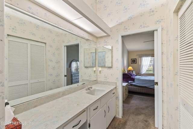 ensuite bathroom with wallpapered walls, ensuite bath, a closet, and vanity