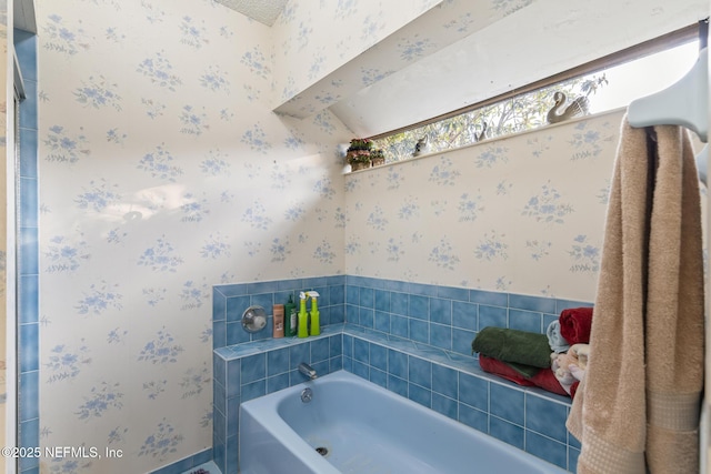 bathroom featuring a bath and wallpapered walls