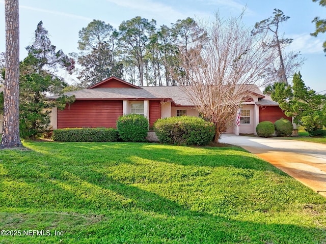 ranch-style home featuring concrete driveway and a front lawn