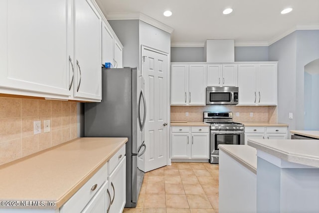 kitchen featuring appliances with stainless steel finishes, white cabinets, and crown molding