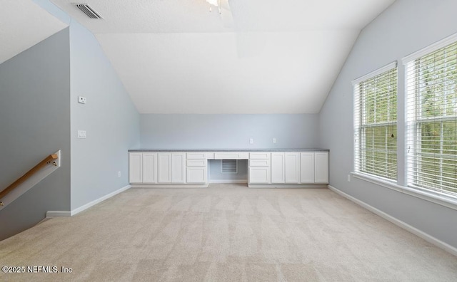 bonus room featuring visible vents, baseboards, light colored carpet, and built in study area